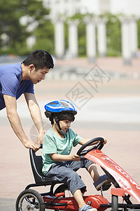 在公园玩赛车的小男孩图片