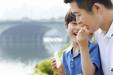  给爸爸吃食物的小男孩图片