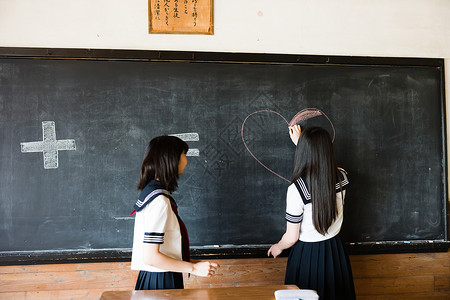在黑板上写字画画的高中女孩农村地区高清图片素材
