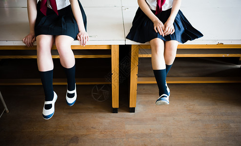 穿着学校制服坐在桌上的女高中生年轻高清图片素材