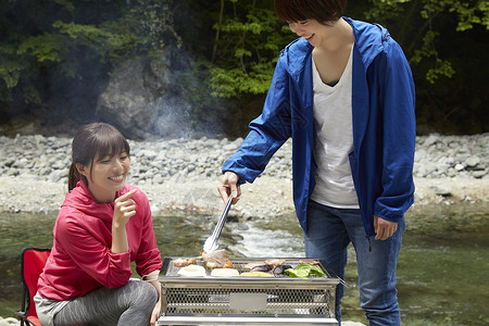 年轻女性开心的吃着刚钓的鱼日本人高清图片素材