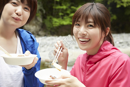 年轻女性在户外吃东西山溪高清图片素材