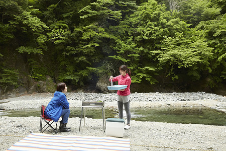 两个女人在河岸边放松享受户外烧烤快乐高清图片素材