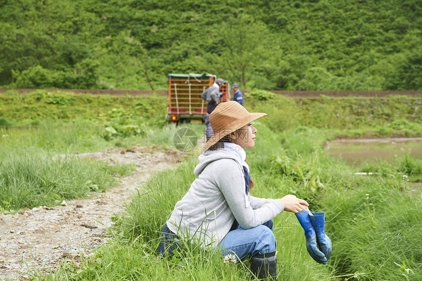 种植水稻在田地里休息的年轻农民图片