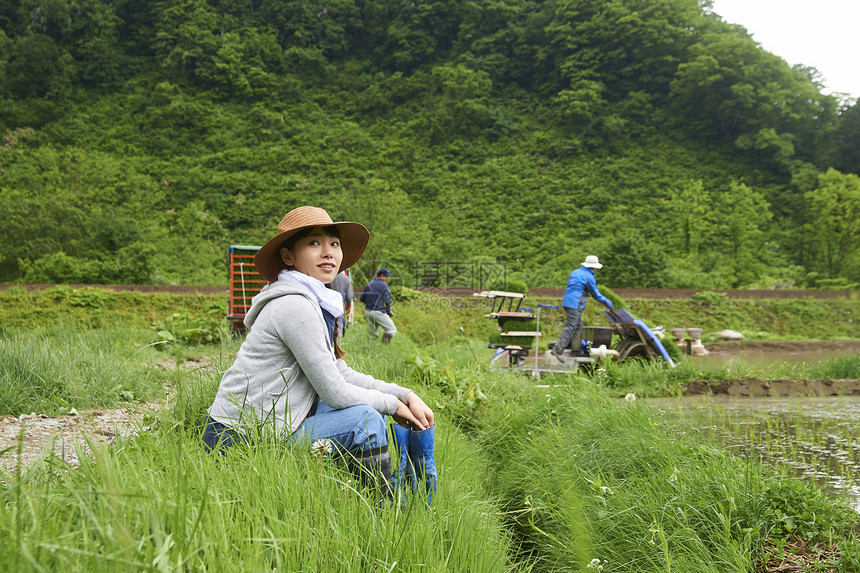 种植水稻后在田里休息的年轻农民图片