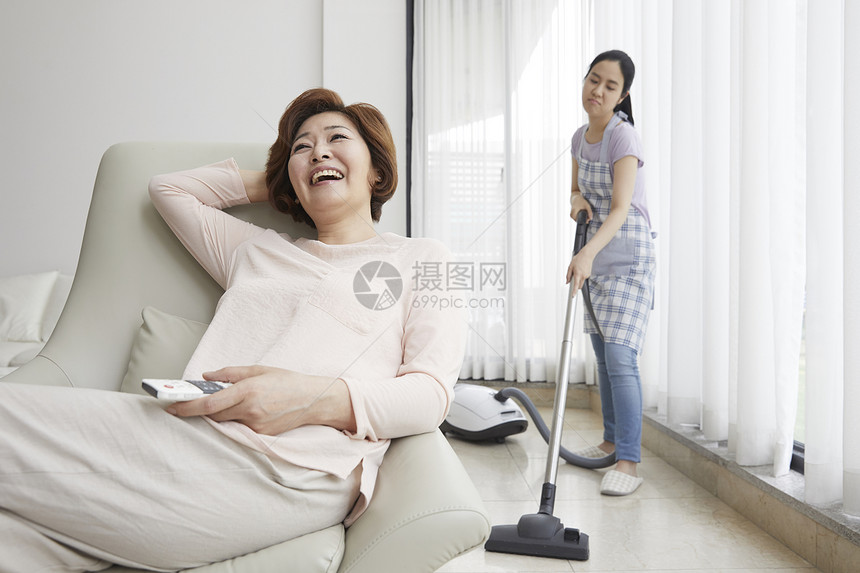 做家务的女儿和妈妈开心的看电视图片