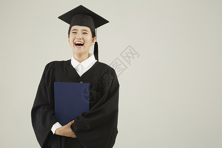 穿毕业礼服的研究生毕业年轻女子高清图片素材