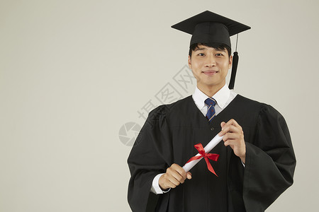 穿毕业礼服的男子手拿毕业证书图片