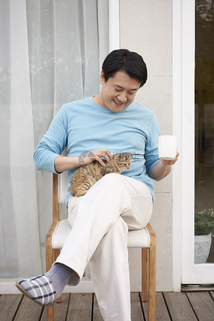 男人在户外和猫一起玩耍图片