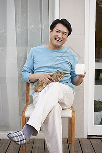 笑着的猫男人在户外和猫一起玩耍背景