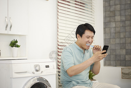 中年男子在刷牙看手机图片