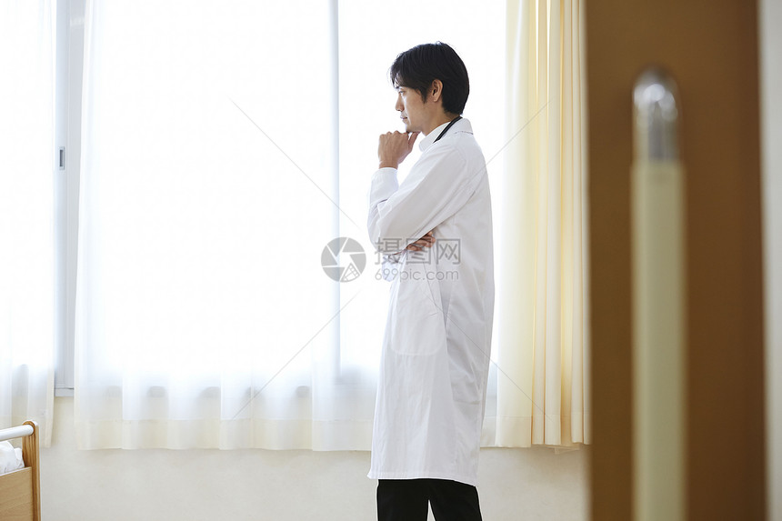 站在窗边的男医生图片