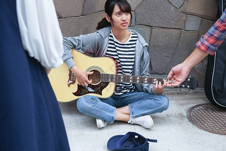 在街头弹吉他卖艺的学生孤独的高清图片素材