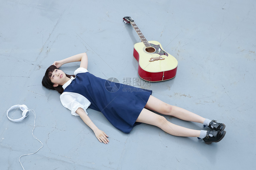 躺在地上的女孩和她的吉他图片