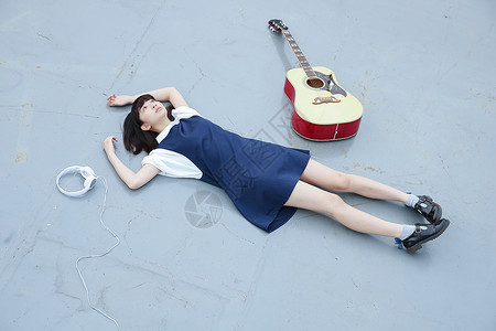 躺在地上的女孩和她的吉他原声吉他高清图片素材