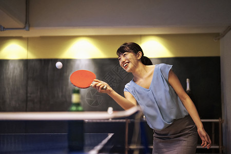 球拍享受肖像打乒乓球的女人图片