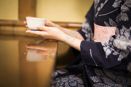 穿着和服拿着茶杯的女性高清图片