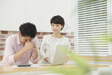 夫妻二人看笔记本电脑十分焦虑失明的高清图片素材