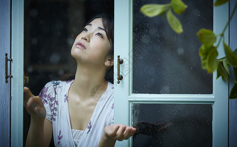 在雨中散步的年轻忧郁女性脸高清图片素材