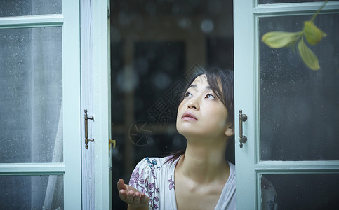 在雨中散步的年轻忧郁女性家高清图片素材