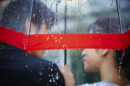 亚洲人有趣笑脸走在雨中的夫妇图片素材