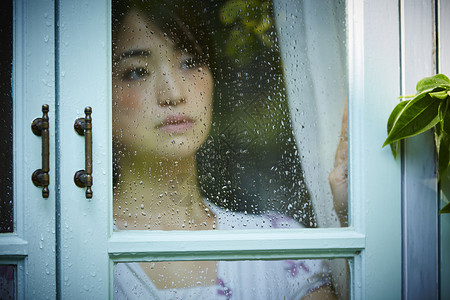 雨天女人在家里度过担心高清图片素材