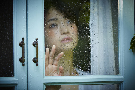 雨天女人在家里度过雨量高清图片素材