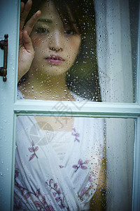 雨天女人在家里度过面部表情高清图片素材