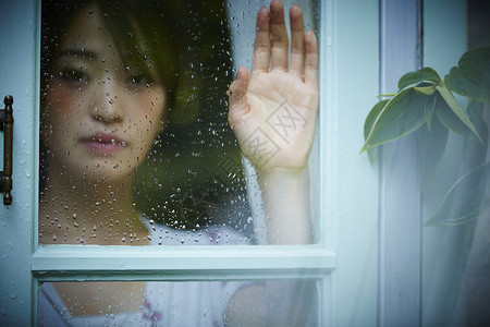 雨天女人在家里度过西式房间高清图片素材