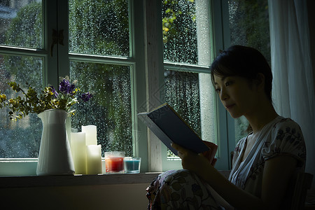 下雨天靠在窗边发呆的孤独女性暴雨高清图片素材