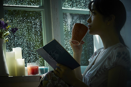 下雨天靠在窗边发呆的孤独女性西式房间高清图片素材