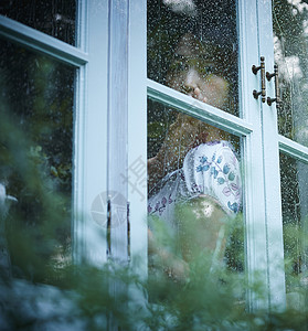 下雨天靠在窗边发呆的孤独女性窗玻璃高清图片素材