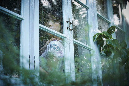 下雨天靠在窗边发呆的女性西式房间高清图片素材