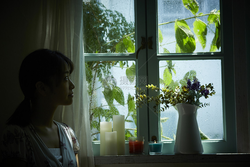 下雨天靠在窗边发呆的女性图片