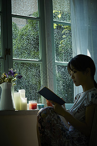 下雨天在窗边放松的女孩独自生活高清图片素材
