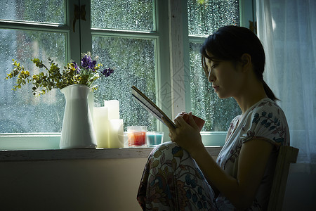 下雨天在窗边放松的女孩假日高清图片素材