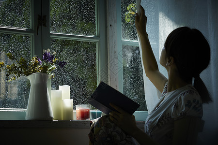 雨天在家看书放松的年轻女性暴雨高清图片素材