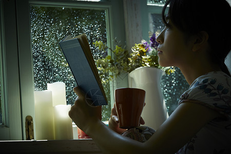 雨天居家看书的女青年休息高清图片素材