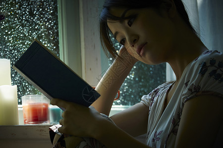 下雨天在窗边放松的女孩孤独的高清图片素材