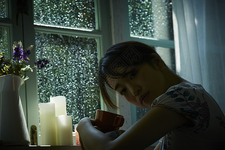 下雨天在家放松喝茶的女青年度假高清图片素材