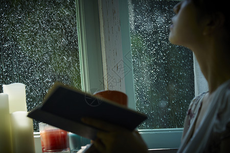 雨夜居家看书放松的年轻女性梅雨高清图片素材