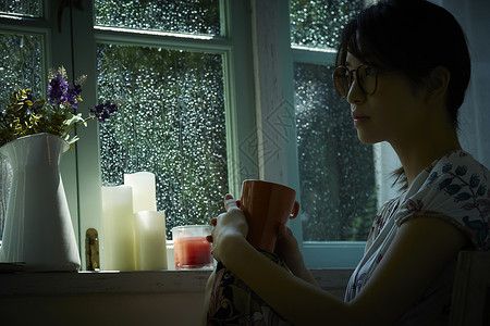 下雨天在室内放松的女性孤独的高清图片素材