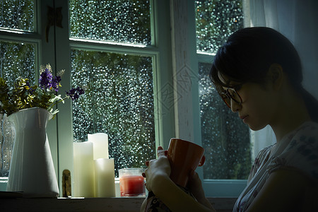 下雨天在家的年轻女性放松的高清图片素材