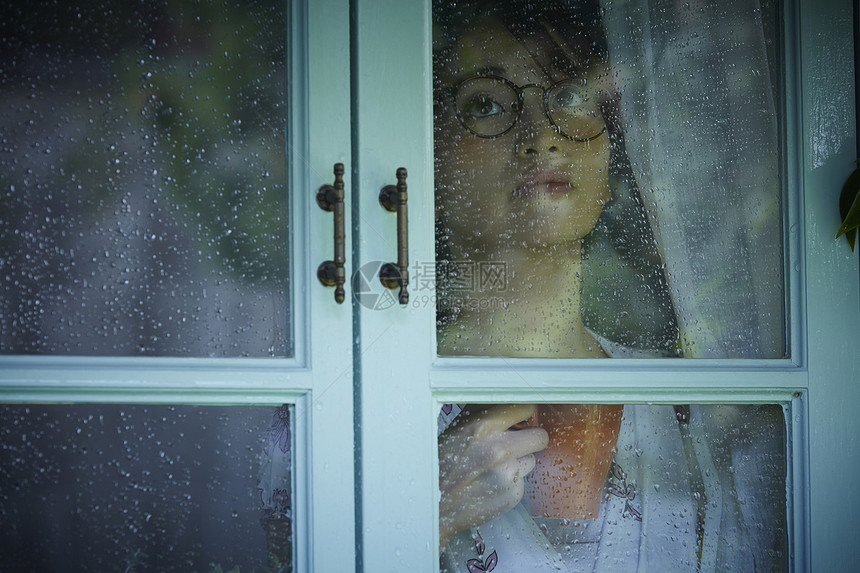 下雨天看向窗外的女青年图片