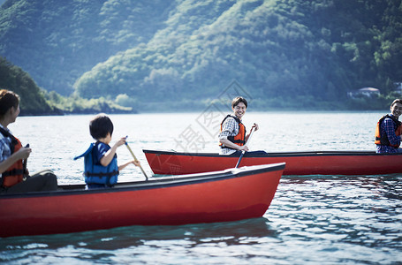 湖泊上划船玩耍的家庭图片