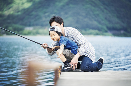 湖边码头享受钓鱼乐趣的父子图片