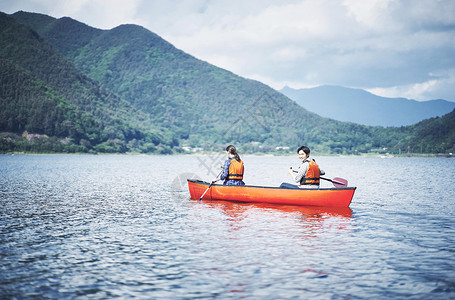 湖泊上穿着救生衣划船的情侣图片