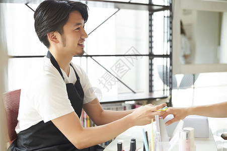 美甲纹秀素材男店员在给客户修美甲背景