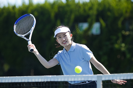 户外网球场打网球的女青年图片