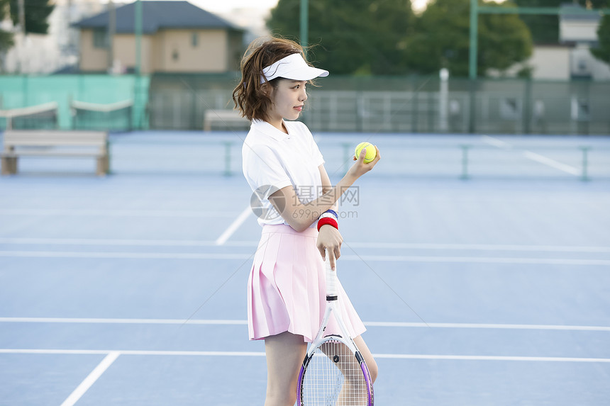 网球场上拿着网球的女孩图片